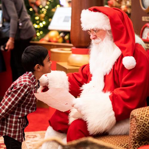 A giraffe looks over a fence.