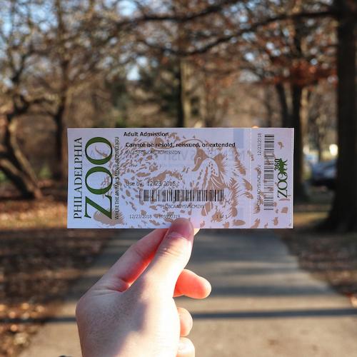 A hand holds up a ticket.